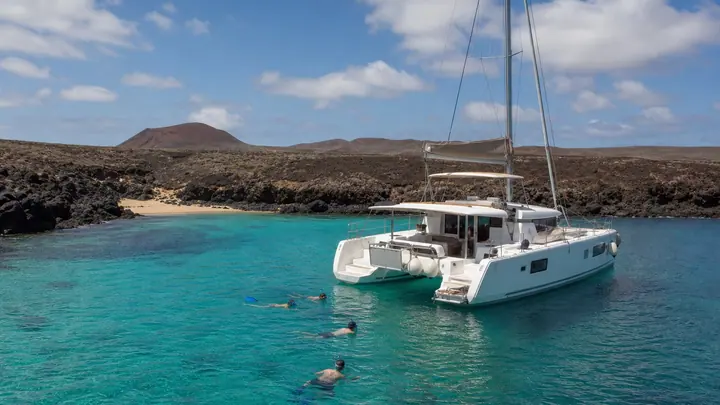 Catamarano in navigazione lungo la costa vulcanica di Isla de Lobos